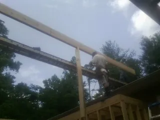 Carpenter setting a ridge beam over a new addition frame — Ice Dam Removal by Roofing Brothers in Adams Run