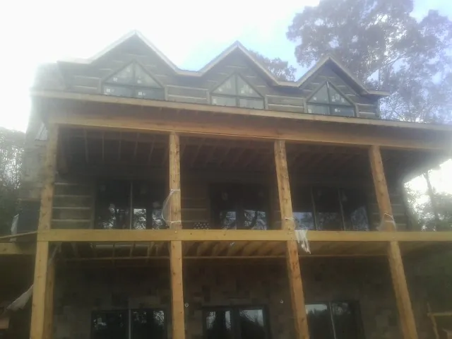 Dormers and porch framing on a large log home under construction — Roof Coating work by our crew in Adams Run
