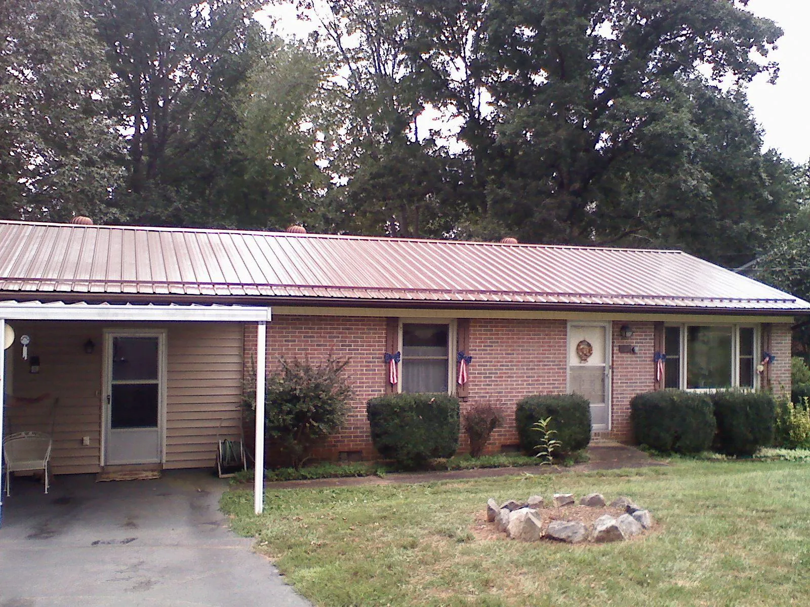 Bronze metal roof and carport on a brick ranch home — Roof Repair work by our crew in Adams Run