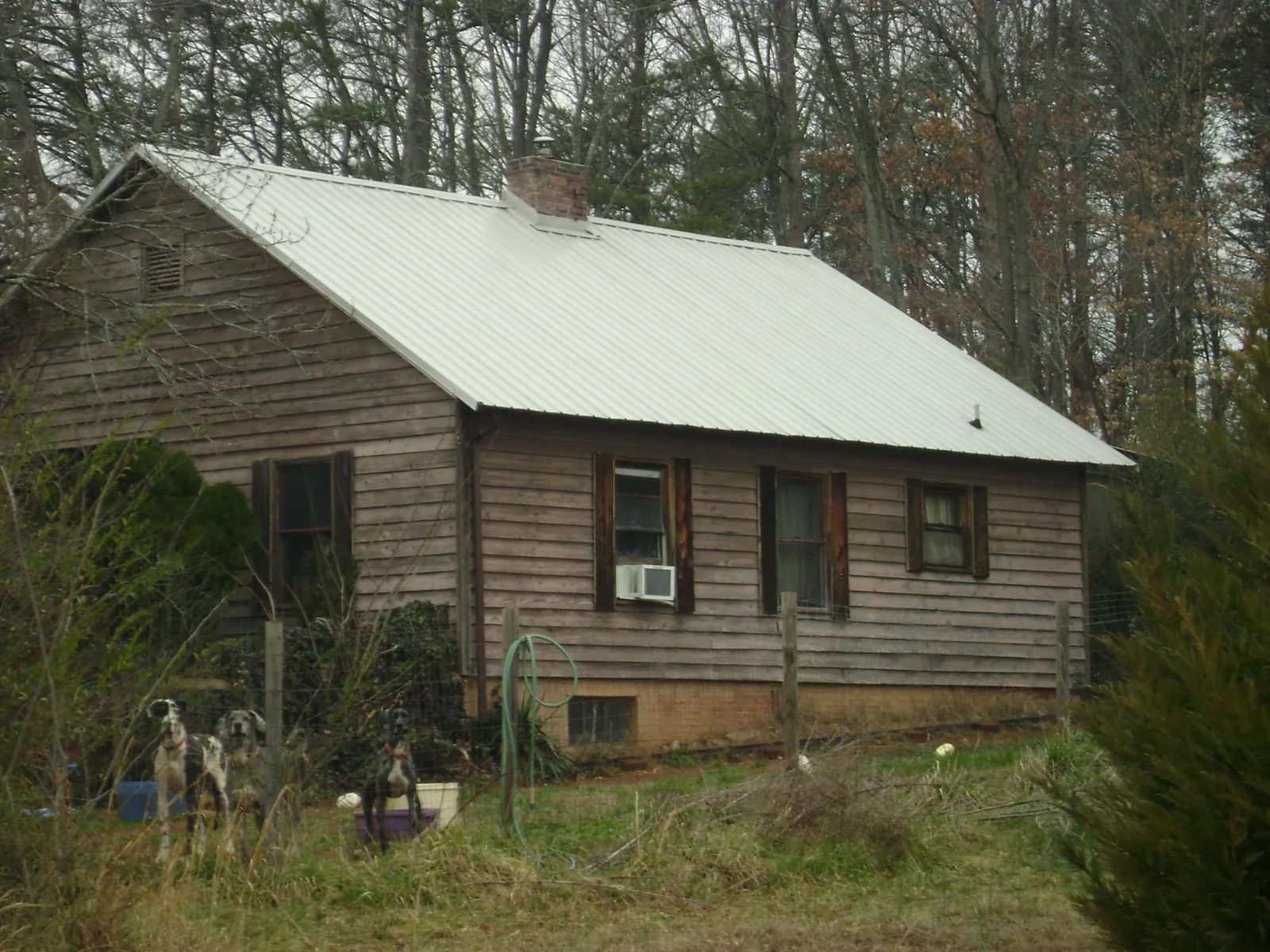 White metal roof on an old wood sided farmhouse, from a Metal Roof Installation job in Adams Run